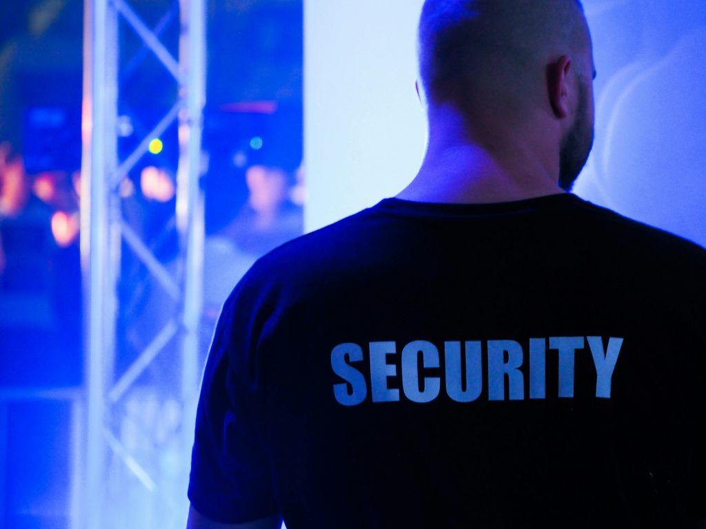 Securtiy A security guard wearing a black shirt in a dimly lit nightclub.
