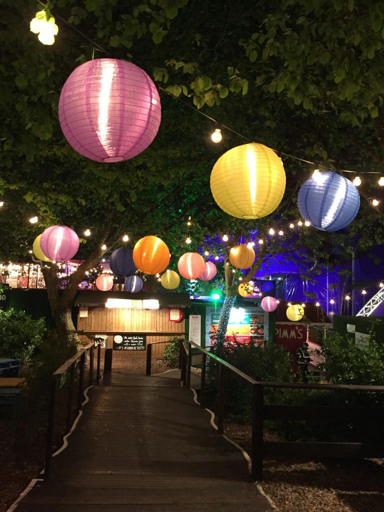 Party Vibrant paper lanterns hanging over a garden path during a festive night celebration outdoors.